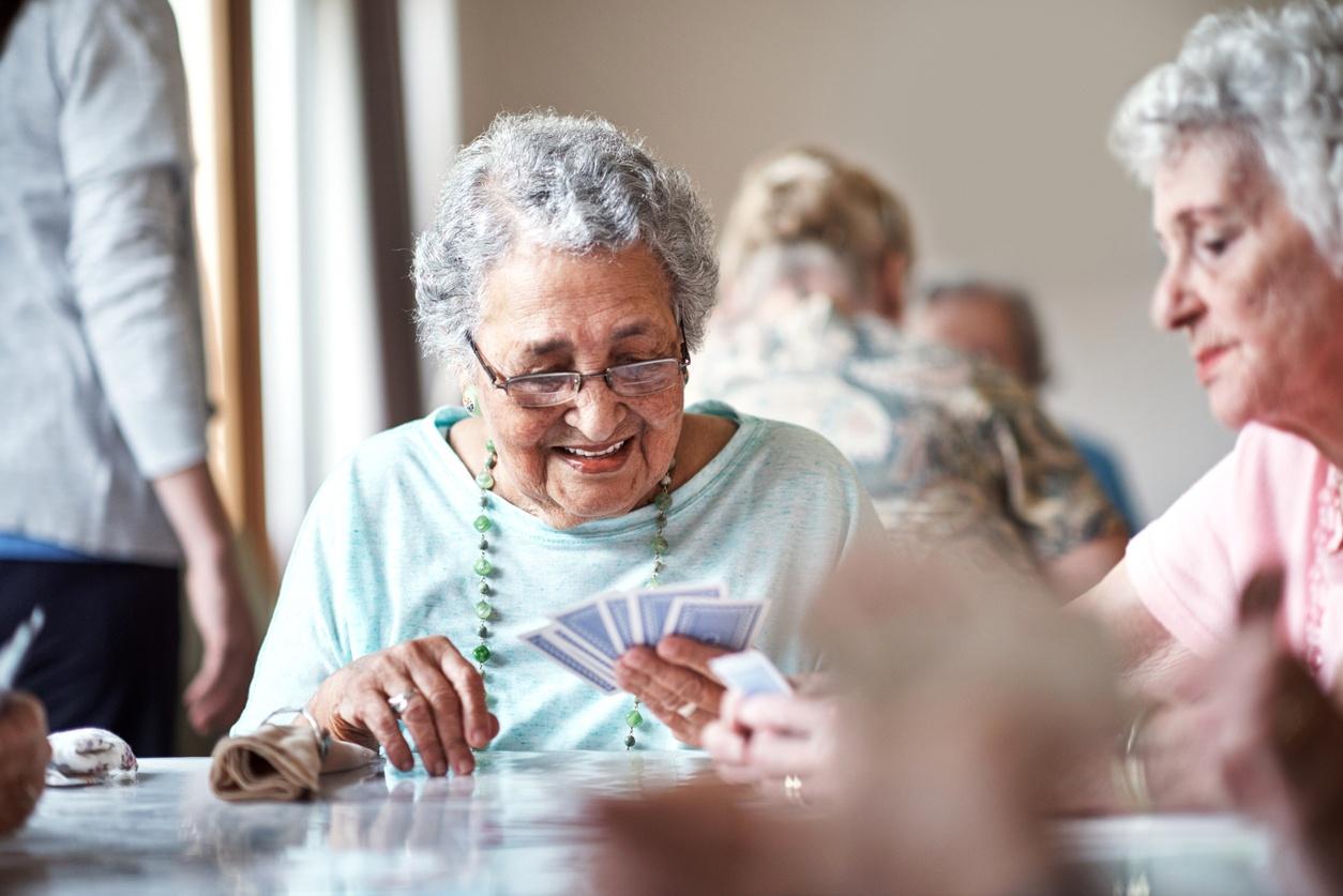 Seniorinnen beim gemeinsamen Kartenspielen – Bestattungsvorsorge für ein sorgenfreies Leben